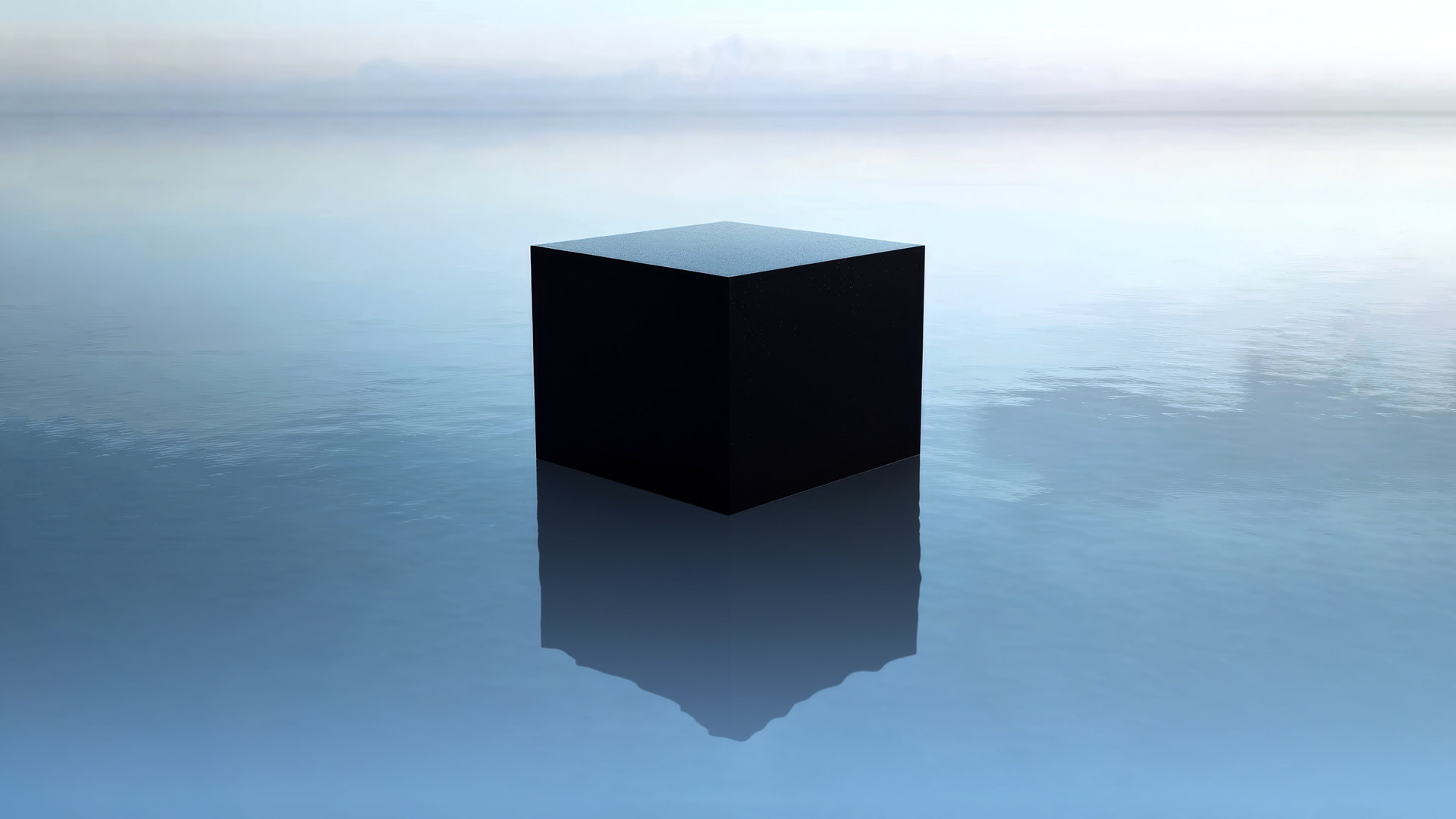 A matte black cube resting on perfectly still, pale blue water beneath an empty sky — a system that gives away nothing about what is happening inside it.